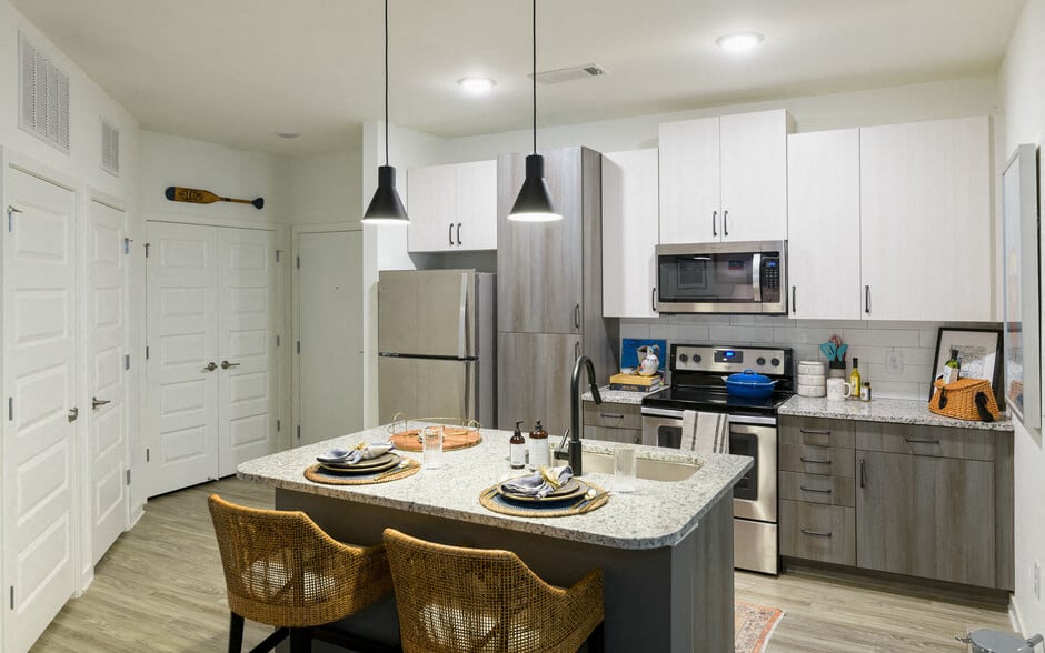 a kitchen with stainless steel appliances and a marble counter top